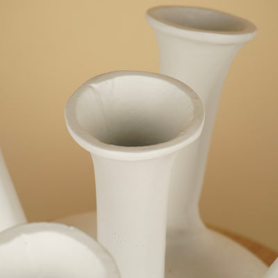 Detail van de uitlopende ronde openingen en witte randen van een tulpenvaas met meerdere halzen.